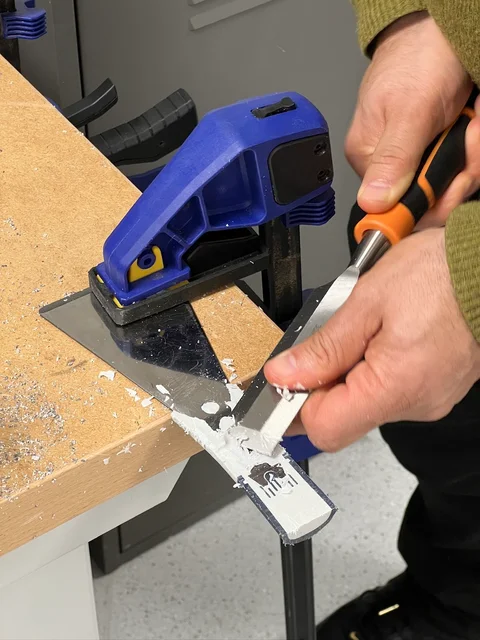 Testing a scraping knife on filler at the workbench