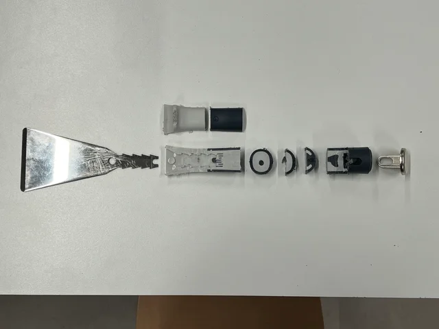 Disassembled scraping knife showing the blade and handle components