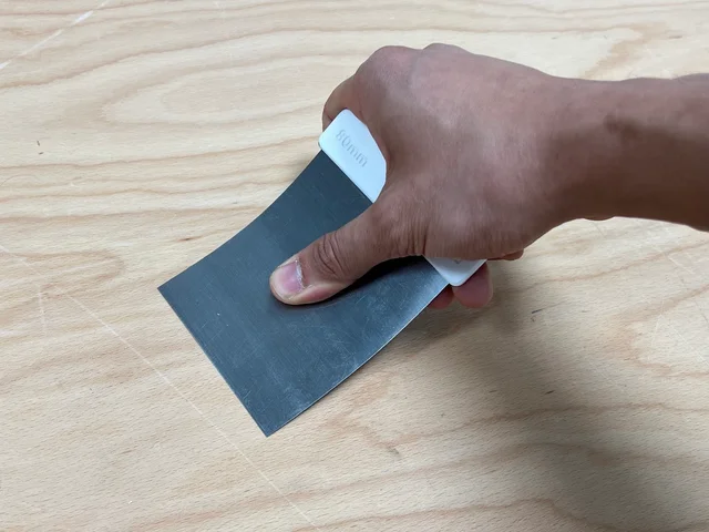 Filling knife held with the thumb pressing directly on the steel blade