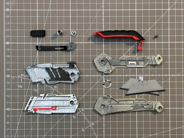 Disassembled utility knife arranged on a gridded cutting mat